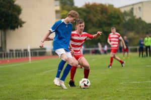 Zwei Fußballspieler duellieren sich im Zweikampf um den Ball