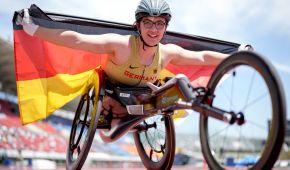 Merle Menje jubelt mit der Deutschlandfahne in ihrem Rennrollstuhl