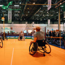 Zwei Menschen im Rollstuhl spielen Badminton
