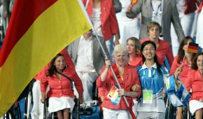 Conny Dietz trägt die Fahne ins Stadion, hinter ihr läuft die deutsche Mannschaft ein