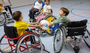 Sportwoche für Alle 2026: Kinder im Rollstuhl spielen in einer Turnhalle mit einem Ball