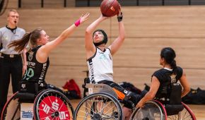 Zwei Rollstuhlbasketballerinnen im Zweikampf um den Ball