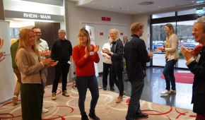 Menschen bewegen sich im Raum und klatschen Beifall