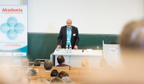 Mann hält in einem Hörsaal einen Vortrag