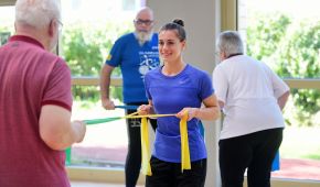 Personen mit Gymnastikband beim Rehabilitationssport