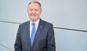 Friedhelm Julius Beucher vor einer grauen Wand