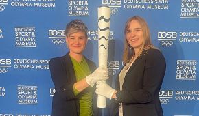 Katja Kliewer und Mareike Miller halten gemeinsam eine Paralympische Fackel