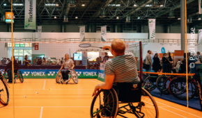 Zwei Menschen im Rollstuhl spielen Badminton