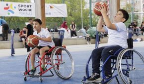 Zwei Jungen probieren bei der Auftaktveranstaltung der SportWoche für Alle Rollstuhlbasketball aus