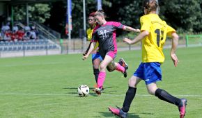 Eine Spielerin setzt bedrängt von einer Gegenspielerin am Strafraumrand zum Schuss an