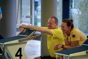 Tanja Scholz und ihr Trainer Michael Pechtel sitzen am Startblock und beobachten.