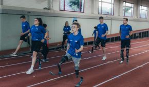 Mehrere Person mit Beinprothese laufen über eine Tartanbahn