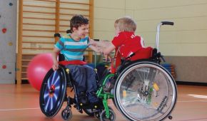 Zwei Rollstuhlkids haben Spaß beim Spielen