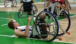 Ein Rollstuhlbasketballspieler liegt auf dem Rücken auf dem Boden