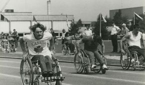 Eine schwarz-weiß Aufnahme des Rollstuhlrennens auf der Tartanbahn