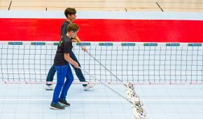 Ein leeres Spielfeld wird von zwei Volunteers gewischt