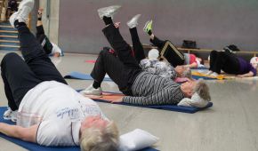 Eine Rehabilitationssportgruppe macht Übungen in Rückenlage