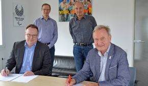 Torsten Burmester gemeinsam mit DBS-Präsident Friedhelm-Julius Beucher an einem Tisch, beide unterschreiben einen Arbeitsvertrage