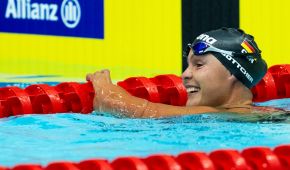 Gina Böttcher nach dem Rennen noch im Wasser, mit breitem Grinsen im Gesicht