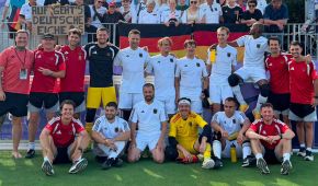 Mannschaftsbild der deutschen Blindenfußballer mit den Fans auf der Tribüne im Rücken