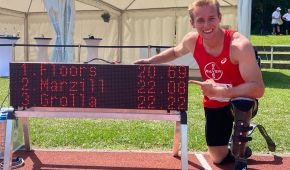Johannes Floors kniet neben der Anzeigetafel mit seiner Weltrekordzeit von 20,69 Sekunden