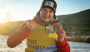 Anna-Lena Forster strahlt in die Kamera und ballt eine Hand zur Faust, in der anderen hält sie ihre Goldmedaille