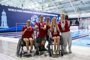 Gruppenbild von mehreren Medaillengewinner*innen bei der Para Schwimm-EM 2026. Drei Athletinnen und zwei Athleten jubeln mit ihren Medaillen in die Kamera.