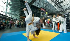 Judo-Kämpferinnen demonstrieren am Berliner Hauptbahnhof vor staunenden Passanten ihr Können