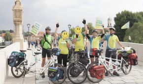 Eine Gruppe Radfahrer steht jubelnd auf einer Brücke und zeigt Schilder "Für mehr Offenheit im Umgang mit Depression"