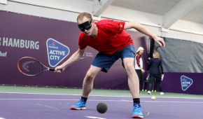 Tennisspieler mit Dunkelbrille setzt holt aus, um Vorhand zu spielen