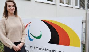 Stefanie Walther steht vor der DBS Geschäftsstelle, im Hintergrund ist das DBS-Logo zu sehen