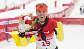 Andrea Rothfuss jubelt mit umgebundener Deutschlandfahne und Maskottchen