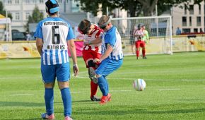Zwei Spieler führen einen Zweikampf um den Ball, ein Spieler von Hertha BSC beobachtet die Situation