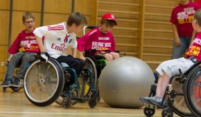 Vier Rollstuhlkids mit einem Pezziball.