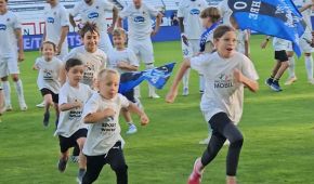 Kinder laufen über ein Fußballfeld