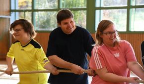 Menschen haben Spaß beim Tauziehen in einer Sporthalle