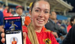 Lise Petersen hält ein Handy mit dem neuen Layout der Team D Paralympics-Seite in die Kamera